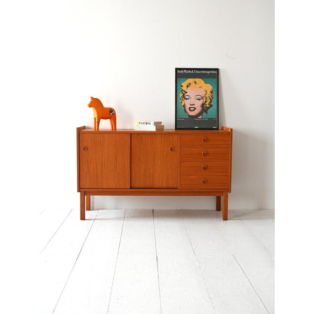 Low cabinet with sliding doors and four drawers, a linear light wood frame, and square legs. Scandinavian-style sideboard...
