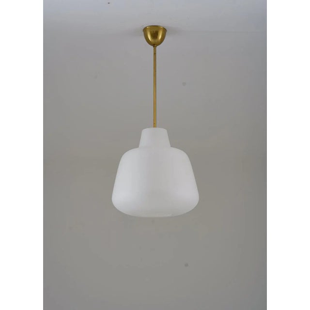 Majestic and beautifully shaped pendants in brass and frosted glass, produced by ASEA in Sweden circa 1940. The frosted...