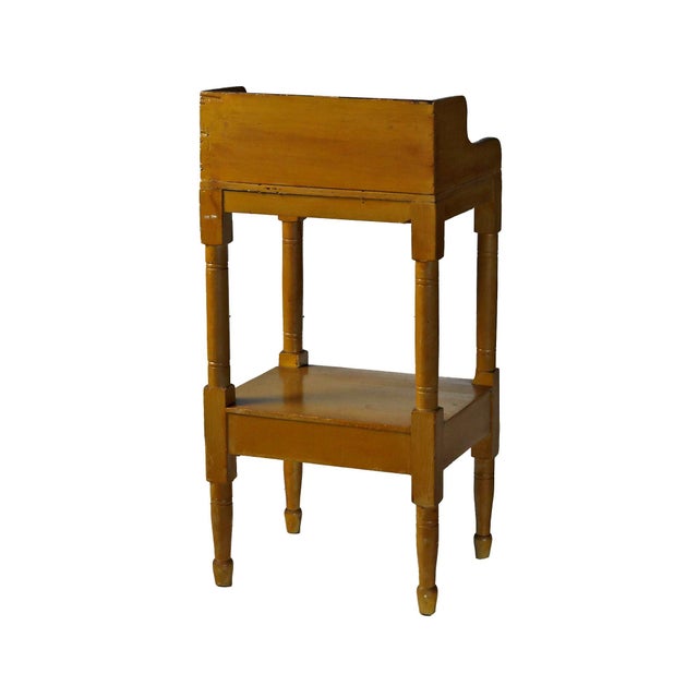 Antique federal washstand with painted decoration, shaped backsplash, one drawer, lower shelf and turned legs.