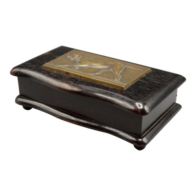 Circa 1900, English ebony box with a hunting or sporting dog bronze plaque. It is handcrafted with a sculpted overhanging...