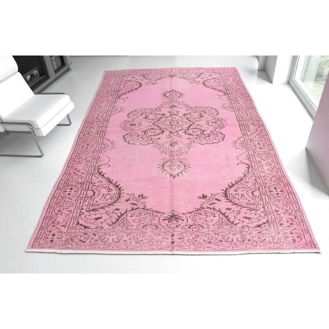 This is a vintage Turkish Oushak rug from the Mid 20th Century. The piece was hand-knotted.