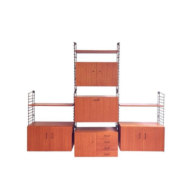 This vintage Musterring teak wall system Musterring a stunning example of thoughtful modular design from the 1960s, where...