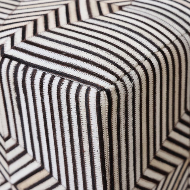 "A refined balance of geometry and warmth, this handmade cowhide leather pouf is one of our best-selling designs,...
