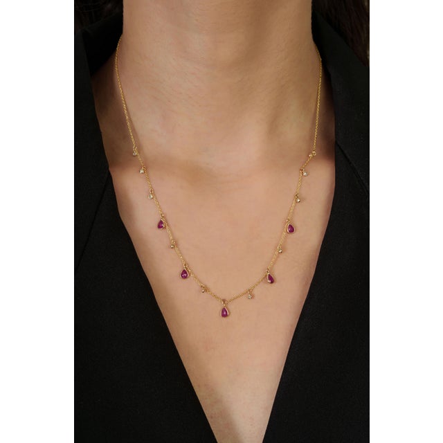 This drop station necklace features a 1.42‑carat pear‑cut ruby set in 14K yellow gold. Each ruby measures approximately 4...