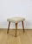 Bouclé stool seat in beige with round beech legs. This vintage stool was manufactured in the 1970s. Completely...