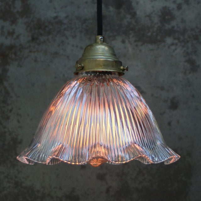 Clear glass lampshade by Holophane, France. Brass glass holder with porcelain bulb holder. 2 meter black wire. This piece...