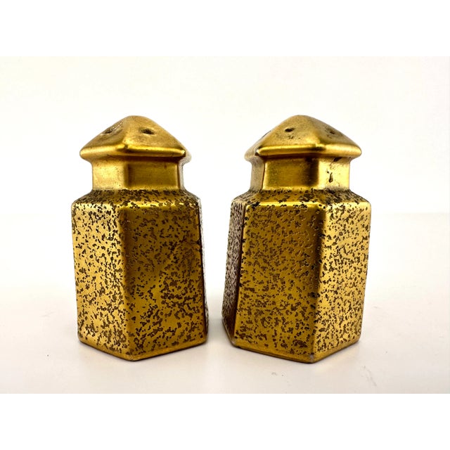 A striking pair of mid-century salt and pepper shakers crafted in Japan, these richly gilded ceramic pieces captivate with...