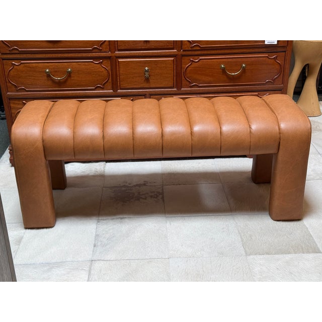 Design Plus Gallery presents a Contemporary Channel-Tufted Upholstered Bench. The sculptural frame is fully wrapped in...