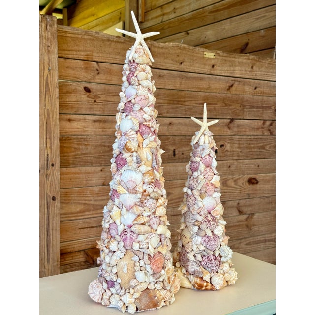 Bring a splash of seaside magic to your holiday décor with this beautifully handcrafted pair of coastal seashell cone...