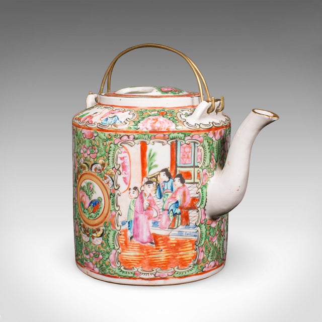 This is an antique Famille Rose teapot. An Oriental, ceramic Chá pot with padded wicker case, dating to the early 20th...