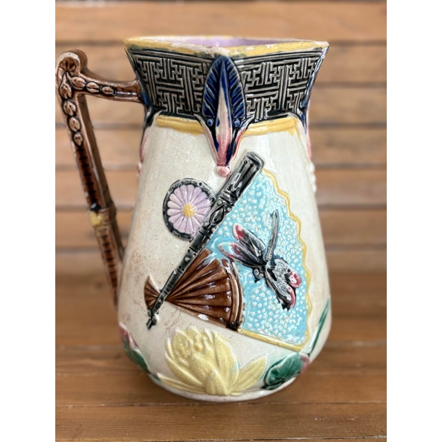 A striking Victorian Aesthetic Movement majolica pitcher featuring bold Japonisme decoration, circa 1875–1885. The design...
