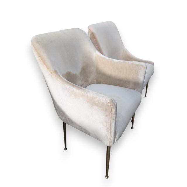 Set of 6 Anthropologie Ellory dining chairs featuring plush light velvet and tapered brass legs; two are armchairs....