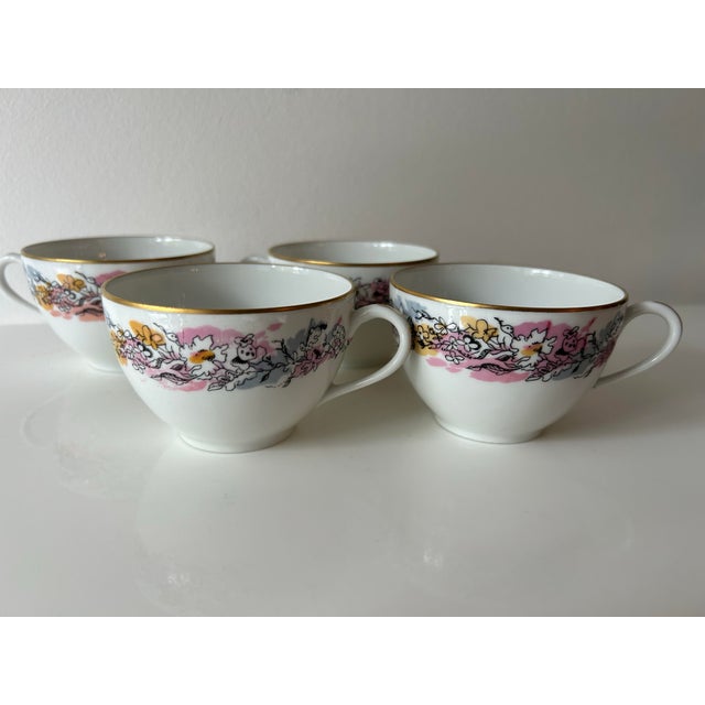 Limoges porcelain cups with gold rim, abstract flowers and splashes of color.