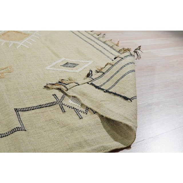 This hand-knotted pile rug is crafted from wool and features a primary color palette of ivory, beige, cream, and white....