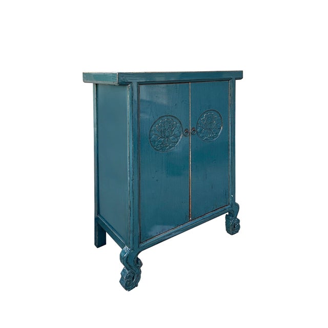 This charming teal blue cabinet exudes vintage elegance with its rich, weathered finish and intricate detailing. The...