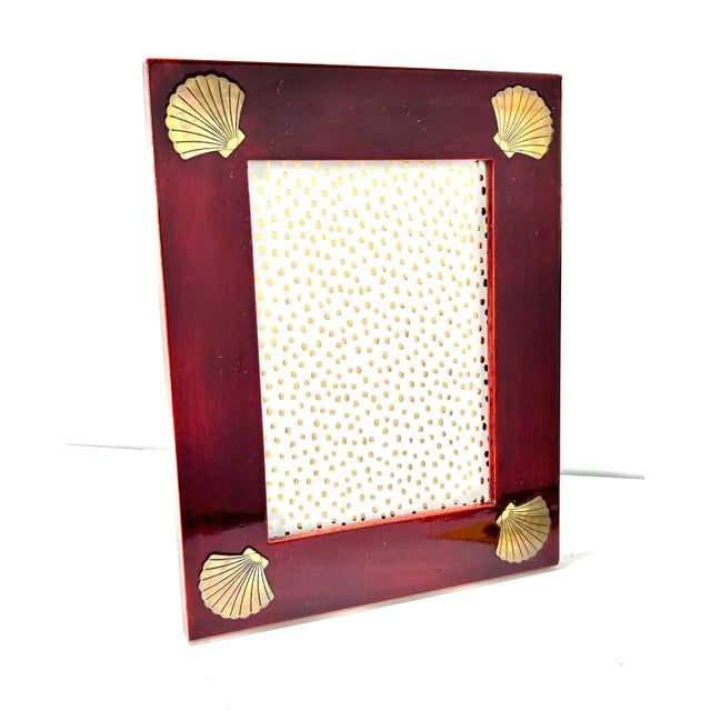 Coastal with a touch of glamour, this rich burgundy lacquered frame is accented with four inlaid, brass seashell corners....