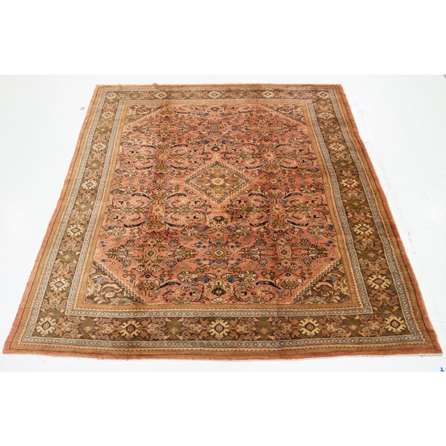 This Persian Mahal hand-knotted wool rug features a pink field with a vibrant multicolor allover design. This rug measures...