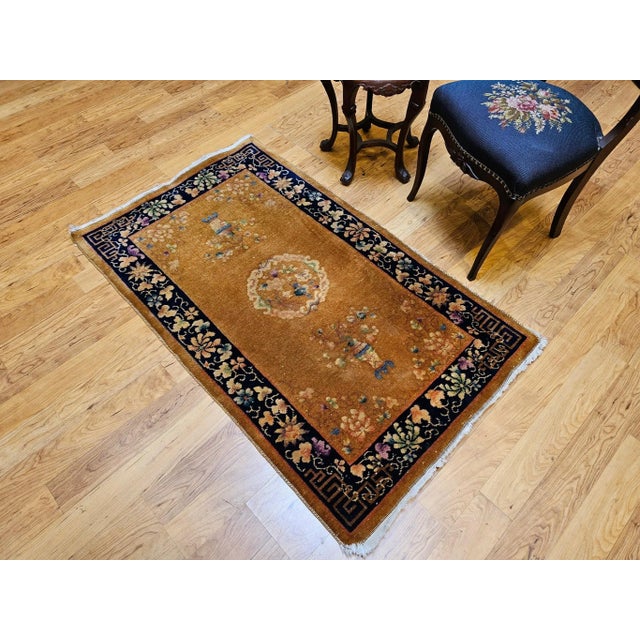 This beautiful vintage Chinese Art Deco area rug from the early 20th century showcases the warm elegance of a caramel-...