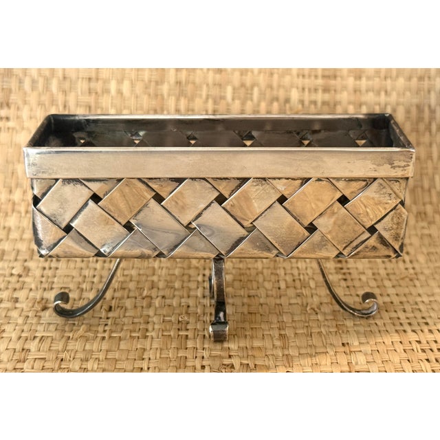 Sterling silver Cartier woven basket. Rectangular shape. Hallmarked on bottom. On 4 curled pedestal legs.