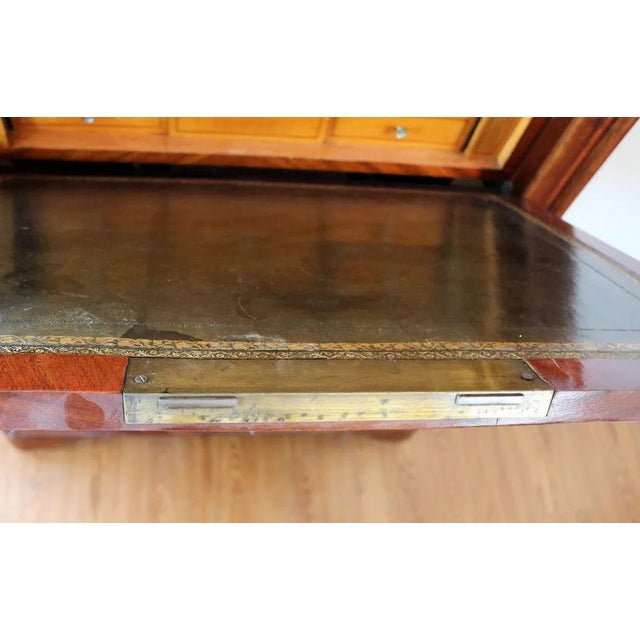 French Secretaire in mahogany feather, upper part in gray marble shaped top with rounded front. A drawer under flared...