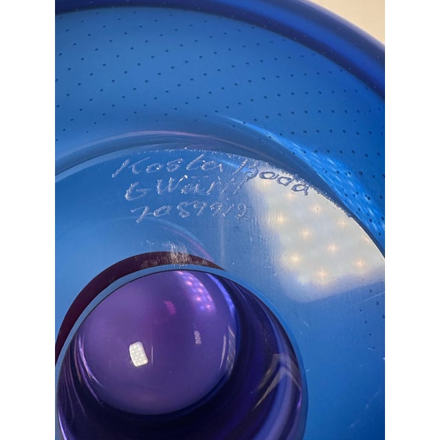 This bowl is a signed 11 inch Costa Boda centerpiece bowl designed by Goran Warff featuring a beautiful blue and magenta...