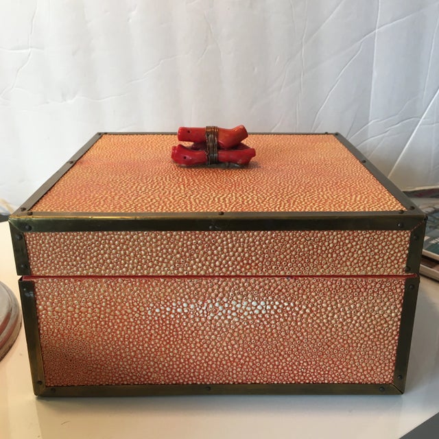Beautiful coral colored shagreen box. The lid has a piece of real coral wrapped in wire. This box has brass surrounding...