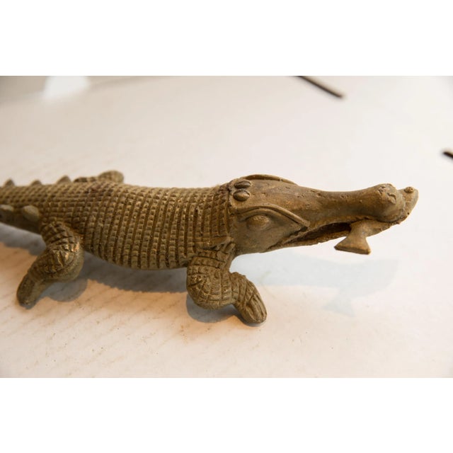 :: Vintage handmade African crocodile with fish sculpture. Circa late mid 20th century, each figure in this collection...