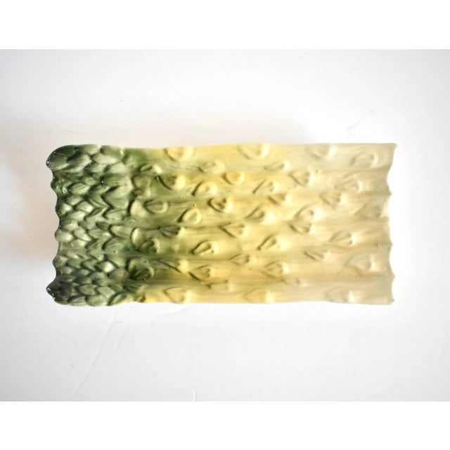 A vintage ceramic pottery trompe l'oeil green asparagus platter or plate in a majolica style glaze, marked on the bottom...