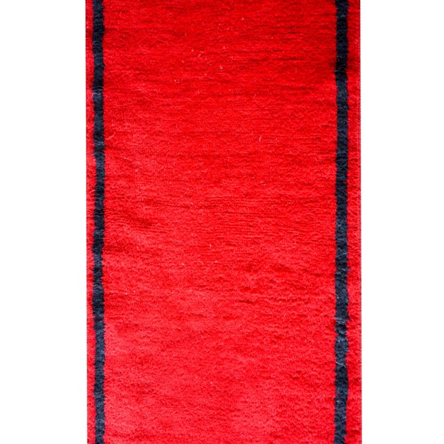 A bold vintage Moroccan runner with a richly colored crimson field and a thin black stipe border.