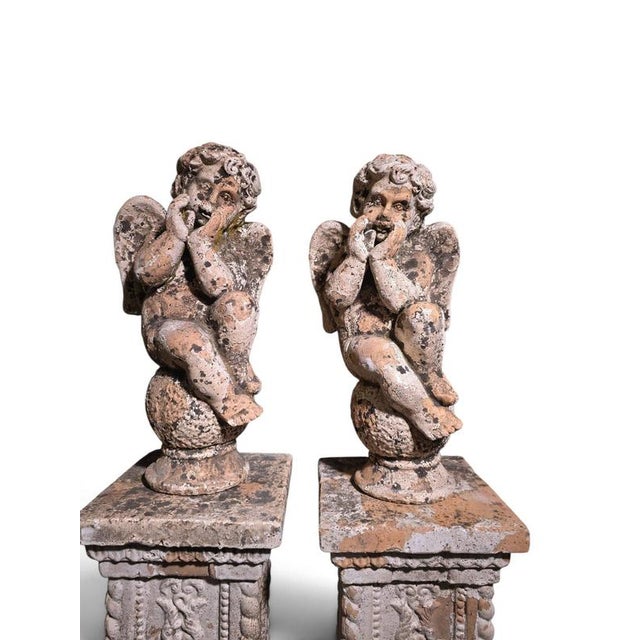 An exceptional and highly decorative pair of 19th-century Italian terracotta cherub sculptures, each presented on its own...