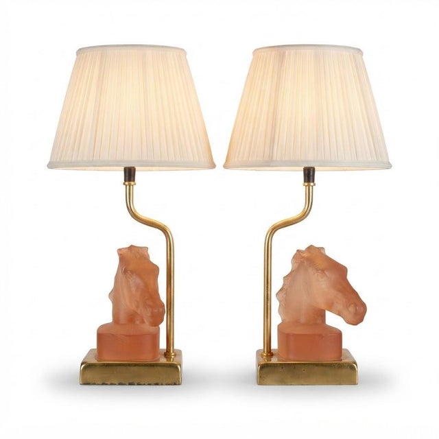 Pair of French table lamps by Le Dauphin from the 1970s. Each features a sculpted horse head in salmon-pink satin glass, a...