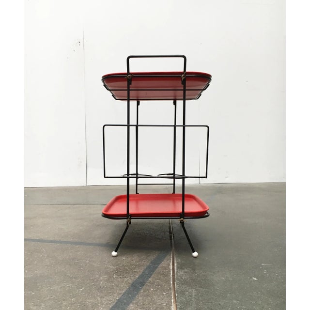 Filigree table with trays and bar. Distinctive coloring in red and black. The frame finely executed consists of black-...