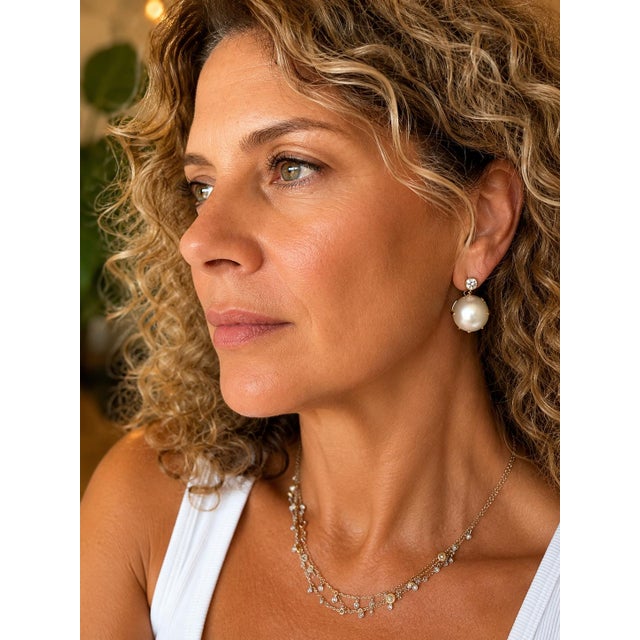 An elegant pair of circa 1990 earrings combining the timeless beauty of South Sea pearls with the brilliance of diamonds....