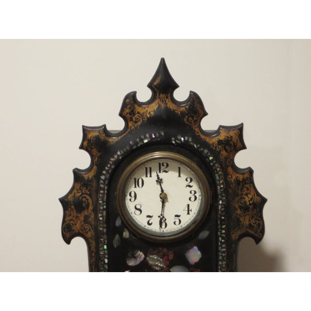 Very unusual mantel clock, with a cast iron face and brown wooden box. This is an eight hour clock in working condition, ....