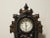 Very unusual mantel clock, with a cast iron face and brown wooden box. This is an eight hour clock in working condition, ....