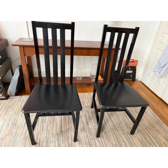 A set of 4 Italian post modern black leather strap dining chairs circa 1980’s. Black lacquered wood frames, black leather...