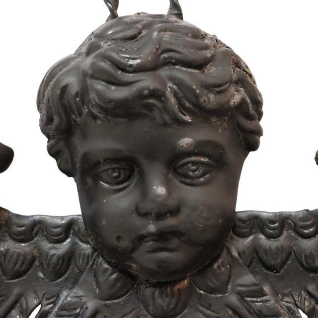 This antique hanging planter, crafted from wrought iron, dates to approximately 1920. The piece features a central figural...