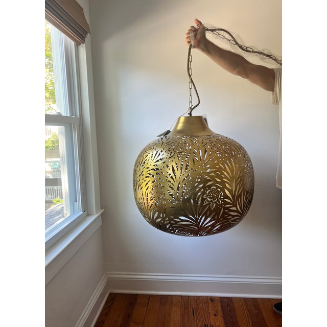 Large brass globe light by Morris & CO. Truly a work of art, the brass-finished pendant radiates a dramatic glow for a...