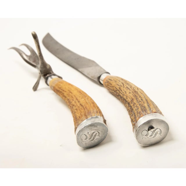 Offering this stunning pair of sterling silver and antler handle carving set. The ends of the antlers are covered in a...