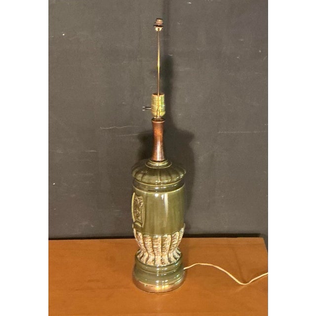 Stunning 1950s-1960s Mid-Century Modern olive green ceramic and wood table lamp. Featuring a cylindrical ceramic body...