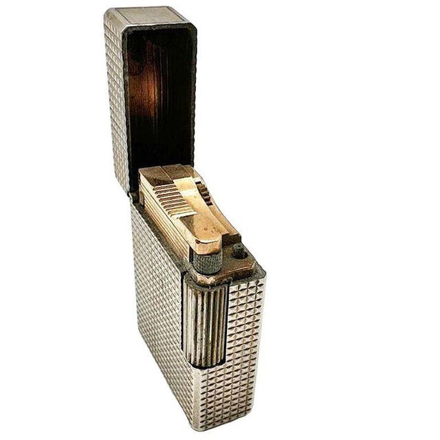 Crafted in silver and gold plate butane lighter with an elegant tiny stud-like textured motif guilloché / hobnail pattern,...
