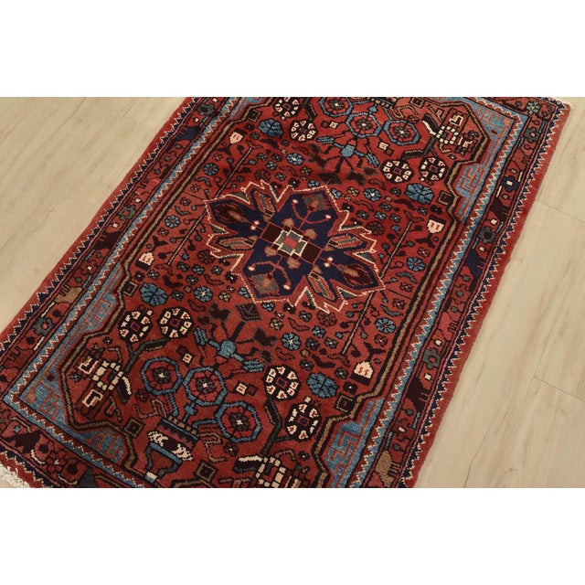An authentic vintage tribal Hamedan rug hand-knotted with fine wool and natural dyes. This nomadic rug features a central...