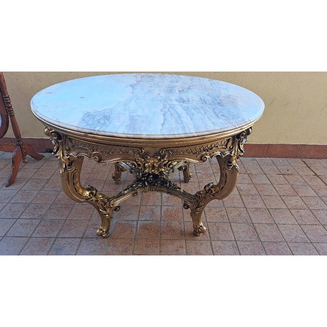 Gilded round table with pink marble top – 1970sImportant round table from the 1970s, featuring a richly gilded frame and...