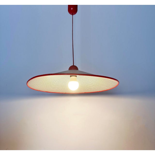 Fun 80s Italian pendant lamp in the typical style of Mathieu Matégot. White perforated metal cap with a red plastic border...