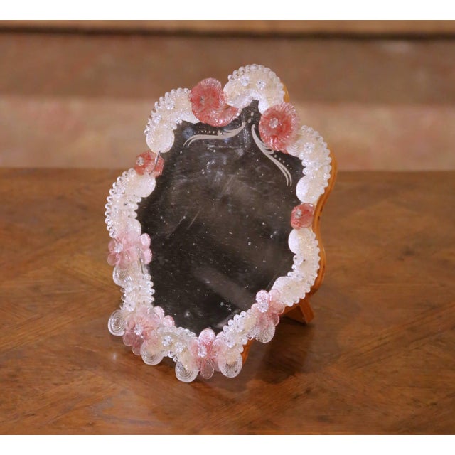 Created in Murano, Italy circa 1960, this elegant antique table mirror reflects the refined tradition of Venetian glass...