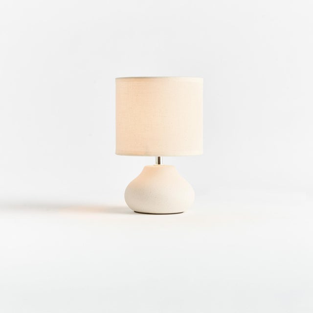 This sweet little ceramic lamp has a curvy silhouette. The wellscaled shade and matte finish complete the look. Perfect...