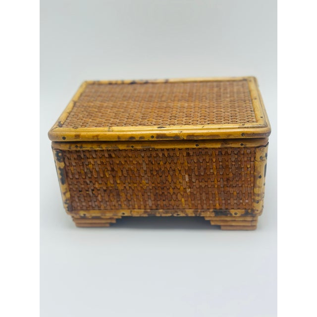 This is an attractive vintage woven wicker and bamboo keepsake box, likely dating to the mid-20th century. The rectangular...