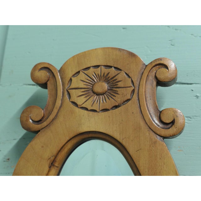 A Trio of Oval Satin Walnut Wall Mirrors The largest mirror is set off with a slightly smaller matching mirror on each...