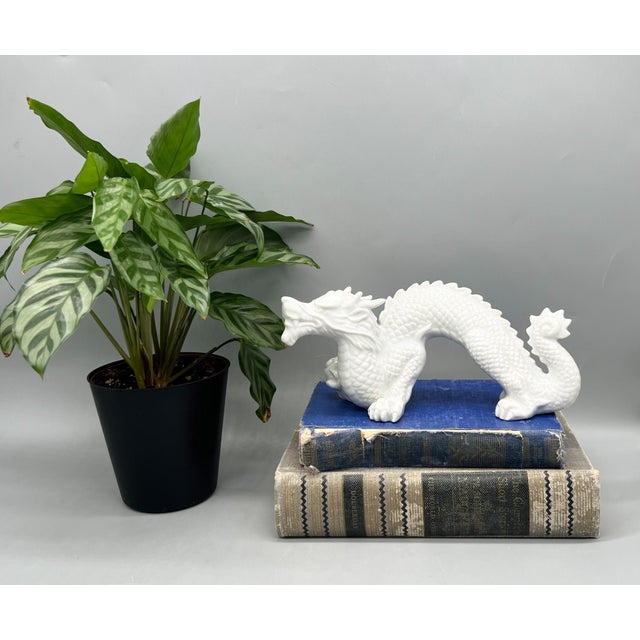 Striking vintage blanc de chine style porcelain dragon, featuring a dynamic arched pose with finely detailed scales,...