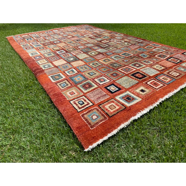 Hand-knotted wool textile featuring a striking geometric composition inspired by traditional Gabbeh weaving. Rendered in...